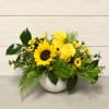 This arrangement features a mix of roses, sunflowers, chrysanthemums, dianthus, greens, and