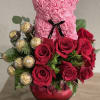Lovely floral arrangement of premium red roses, assorted greens, premium chocolates to