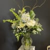 Soft, serene and timeless, this arrangement features lush hydrangeas, graceful white lilies