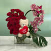 This marvelous arrangement has a cymbidium orchid, brilliant red roses, a beautiful