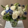 Exciting bunch of blue, white and green flowers in a clear glass