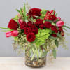 Red roses and tulips sitting on a bed of hydrangeas for any