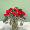 This bright and beautiful arrangement has vibrant red anemones and soft dusty