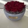 Preserved pink roses elegantly displayed in a textured stone vase. Will stay