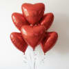 Half dozen red heart shaped mylar balloons.
