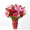 This lush arrangement features hot pink roses, carnations and alstroemeria to color