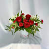 Elegant arrangement features vibrant red roses, charming white alstroemeria, and red carnations