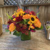 A bright and cheerful arrangement, with sunflowers, tiger lilies, roses and much