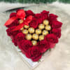 Ferrero chocolates surrounded by red roses in a heart shaped short box.