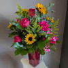 A dazzling arrangement of pink roses and sunflowers in a pretty pink