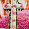 This is a beautiful cross with white and pink roses.