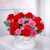 A luxurious arrangement of fresh red and pink roses designed in an