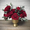 One dozen Hearts garden roses gathered in a gold ceramic vase.