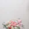 A charming floral basket featuring a lush arrangement of premium blooms paired