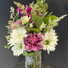 Beautiful arrangement with snapdragons, carnations, daisies, limonium and greens in a clear