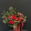 A stunning Christmas luxury arrangement featuring premium red roses, fresh winter greenery