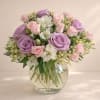 An elegant mix of white and purple flowers in a glass vase