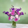 This arrangement has purple stock, pink and purple mini gerbera daisies, and
