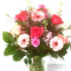 Gerbera daisies hot pink roses and lots more in a clear vase