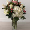 An elegant floral arrangement featuring white hydrangeas beautifully paired with white and