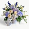 A beautiful white vessel filled with a grand tribute in lavender and