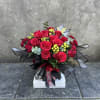 Romantic red roses, spray roses, berries, and eucalyptus. Elegantly wrapped and tied