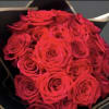 24 red roses wrapped in black floral paper