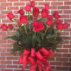 Twenty-four vibrant red roses arranged with greens and a large red bow