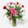 A dozen mixed colored rosesBeautifully arranged in a glass vase with a