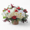 A graceful mix of white orchids, red and white roses, hydrangeas, evergreens