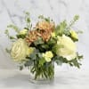 Low arrangement of white roses, coral mums, green thistle, pale yellow French