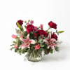 A class clear cylinder filled with romantic lilies and roses