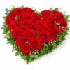 A stunning heart-shaped arrangement made with premium red roses and lush greenery.