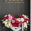 A lush garden-style arrangement featuring premium red, blush, and ivory roses accented