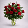 Twelve premium red roses, artfully arranged with fresh greenery in a clear