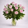 Twelve premium blush pink roses, gracefully arranged with lush greenery in a