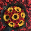 A bold mix of vibrant red roses and cheerful sunflowers, combining classic