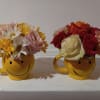 Cute smiley face expresso size cup with the various flowers arrangements