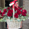 Basket of red roses with eucalyptus and a red ribbon