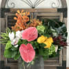 Tropical and more tropical flowers in Clear vase with seashells.