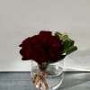 A pave of roses in a glass vase with an accent of