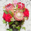 This long-lasting arrangement of red Roses, Protea and fragrant Hyacinth are nestled