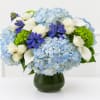 This white and blue arrangement includes blue hydrangea, blue hyacinth, green hydrangea