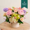 This flower arrangement features soft pastel-toned flowers, including fragrant Pink O'Hara garden