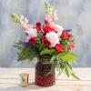 This 6.25" red vase is filled with pink roses, snap dragons and
