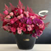 A pink, red, and purple rose arrangement combines the romantic allure of
