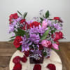 A romantic mix of roses, tulips, and seasonal blooms in a red