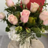 Pink roses in a glass vase with additional flowers for a cottage