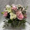 Pink lilies, roses, spray roses, alstroemerias, baby breath arranged in a clear
