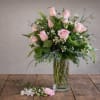 This elegant vase features a beautiful arrangement of pink roses and delicate